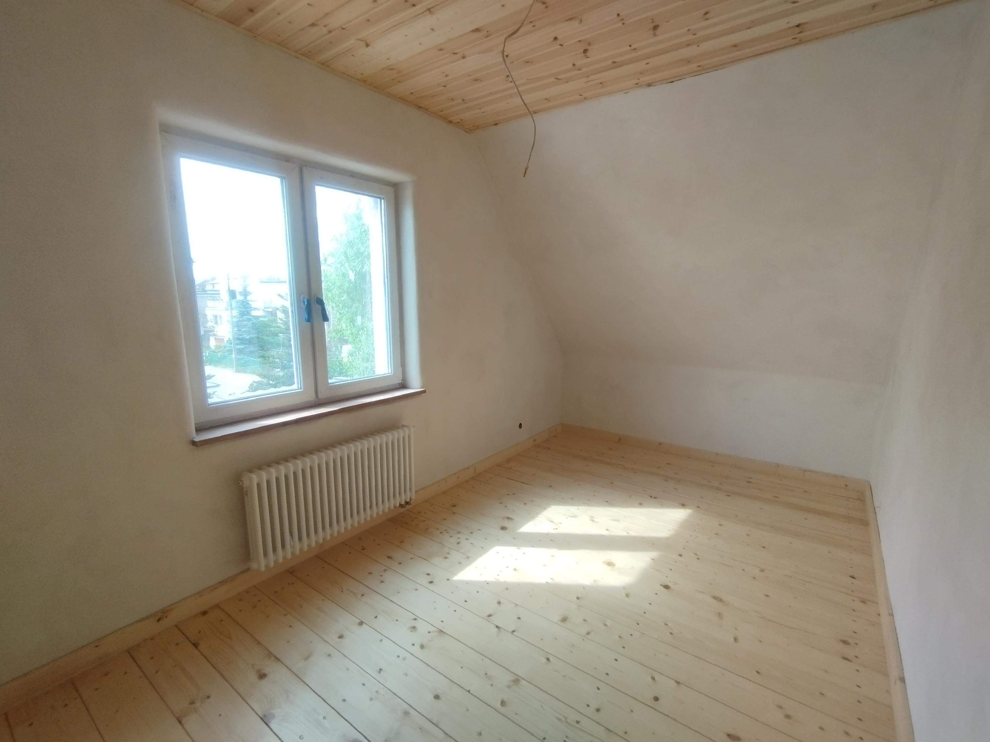 pokój na poddaszu z tynkiem wapiennym i drewnianą podłogą